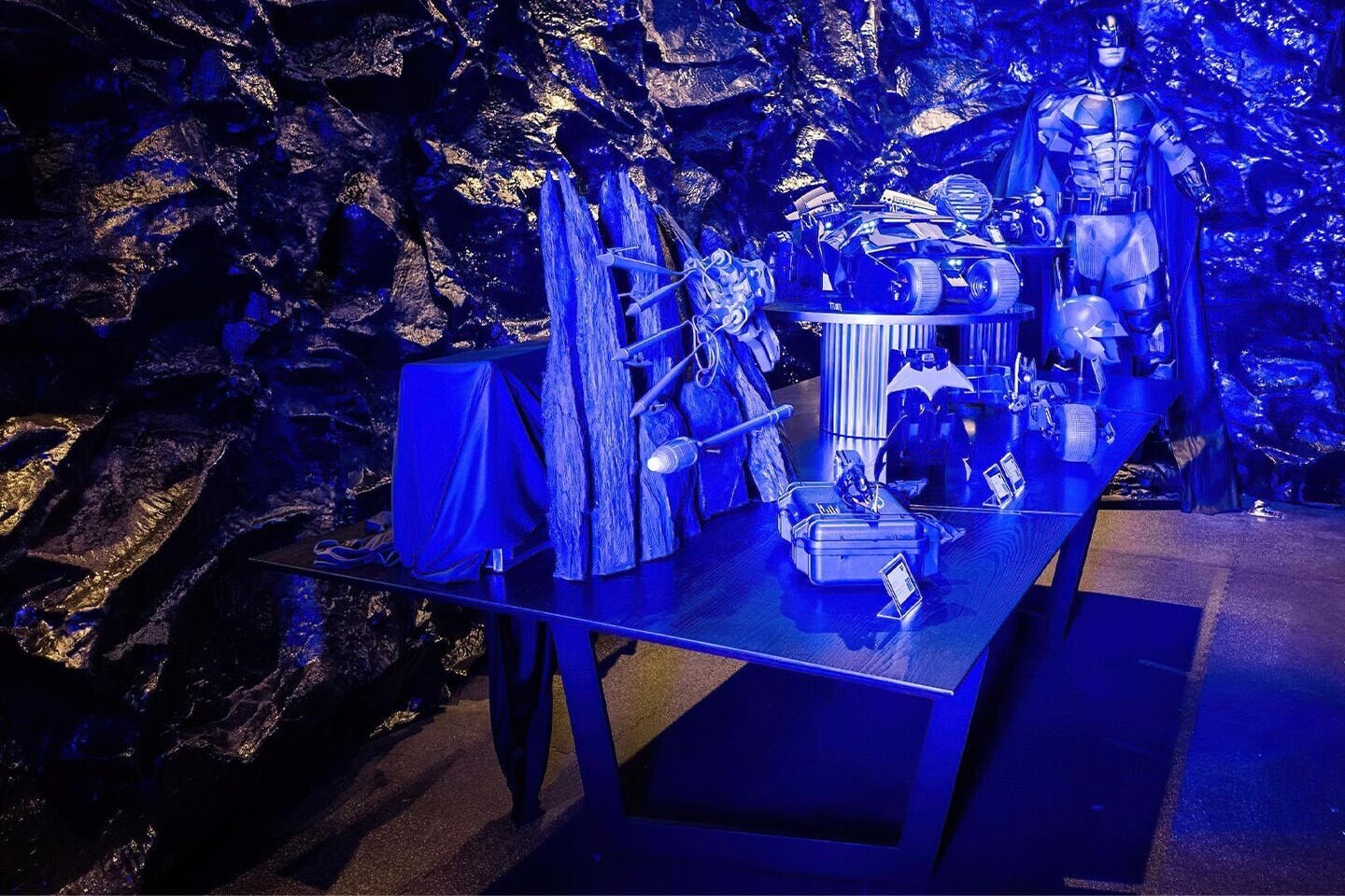 V „Batcave“ ve sklepních prostorách newyorského domu Bruce Waynea se nacházejí různé hračky a udělátka, včetně modelu Batmobilu, kovového Batarangu a modulárního vystřelovacího háku Batman i989.